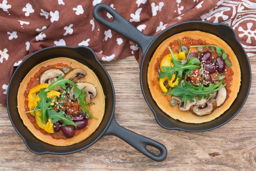 Socca-Pizza (Kichererbsenfladen) mit Pesto, Oliven und Rucola