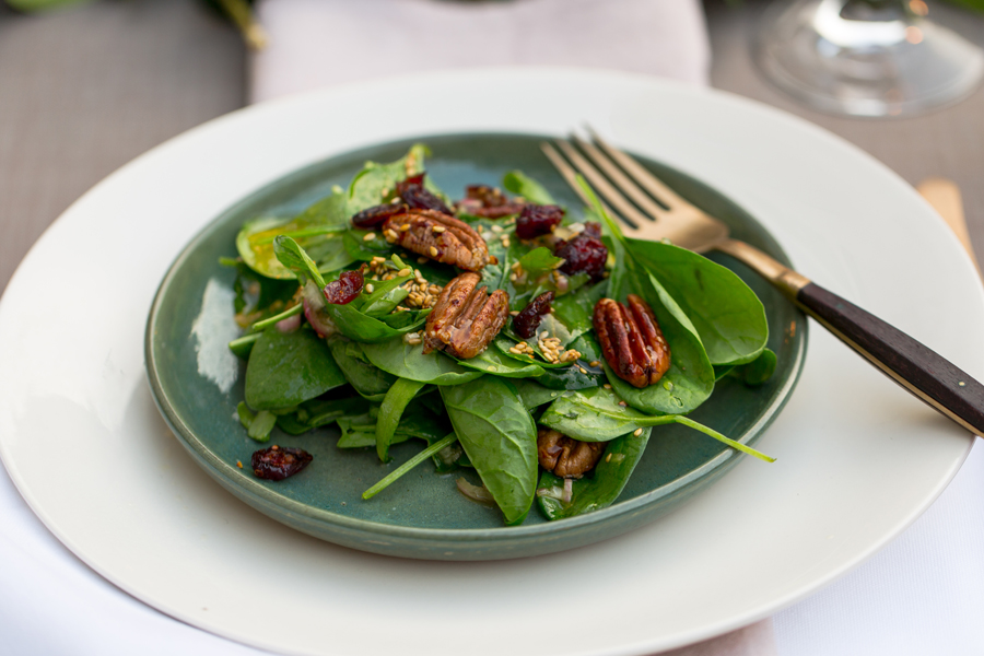 Kandierte Pekannüsse und Cranberries auf frischem Spinatsalat, mit geröstetem Sesam-Dressing Kandierte Pekannüsse und Cranberries auf frischem Spinatsalat, mit geröstetem Sesam-Dressing
