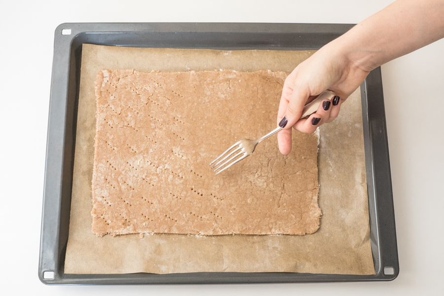 Das Backpapier mit dem Teig auf ein Backblech legen und mit einer Gabel einstechen. Bei 180°C 10 Minuten vorbacken.